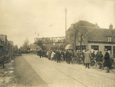 42107 Gezicht op een rij wachtende mensen voor de spoorwegovergang in de Amsterdamsestraatweg te Utrecht, uit het ...